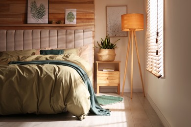 Photo of Comfortable bed with new pistachio linens in modern room interior