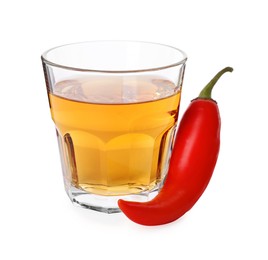 Photo of Red hot chili pepper and vodka in glass on white background