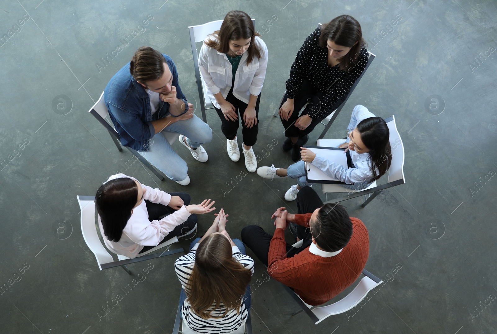 Photo of Psychotherapist working with patients in group therapy session, top view