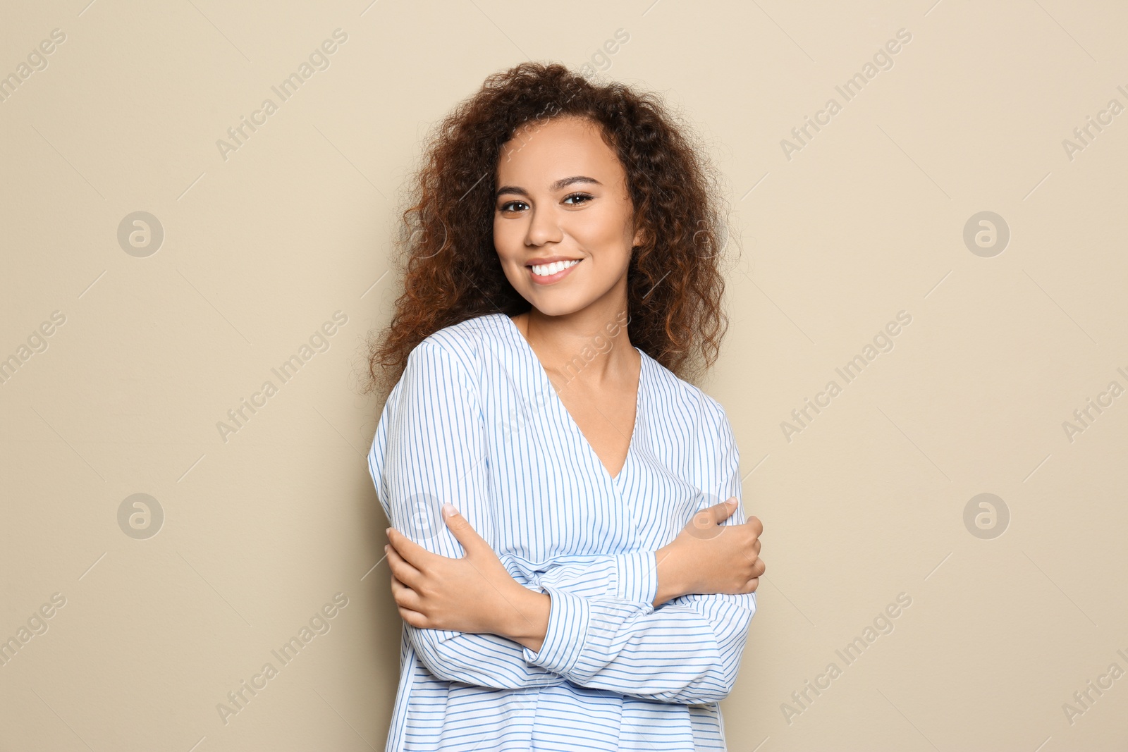 Photo of Young African-American woman with beautiful face on beige background