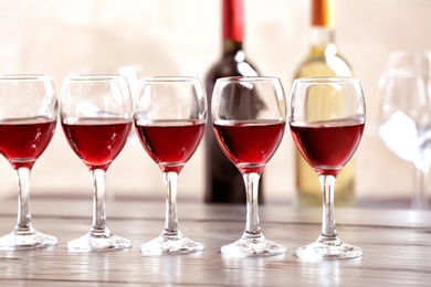 Photo of Glasses with delicious red wine on table