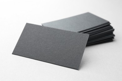 Photo of Blank black business cards on white table, closeup. Mockup for design