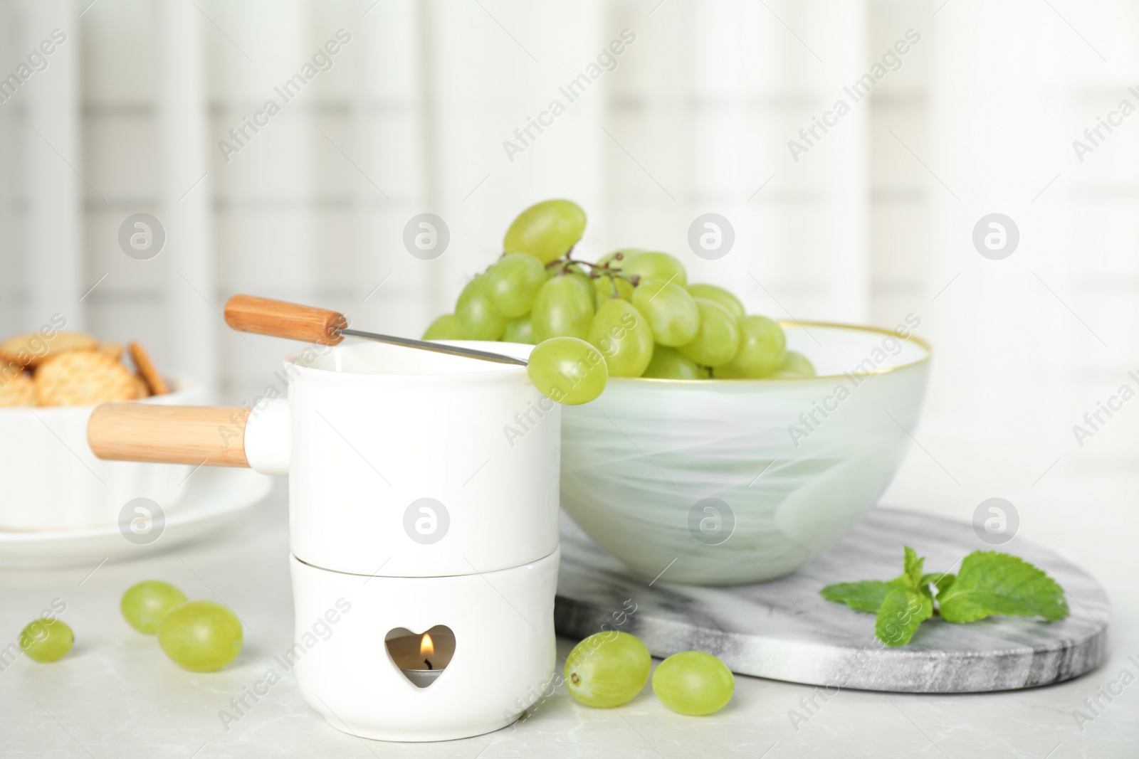 Photo of Fondue pot and products on table indoors