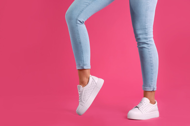 Photo of Woman wearing shoes on pink background, closeup