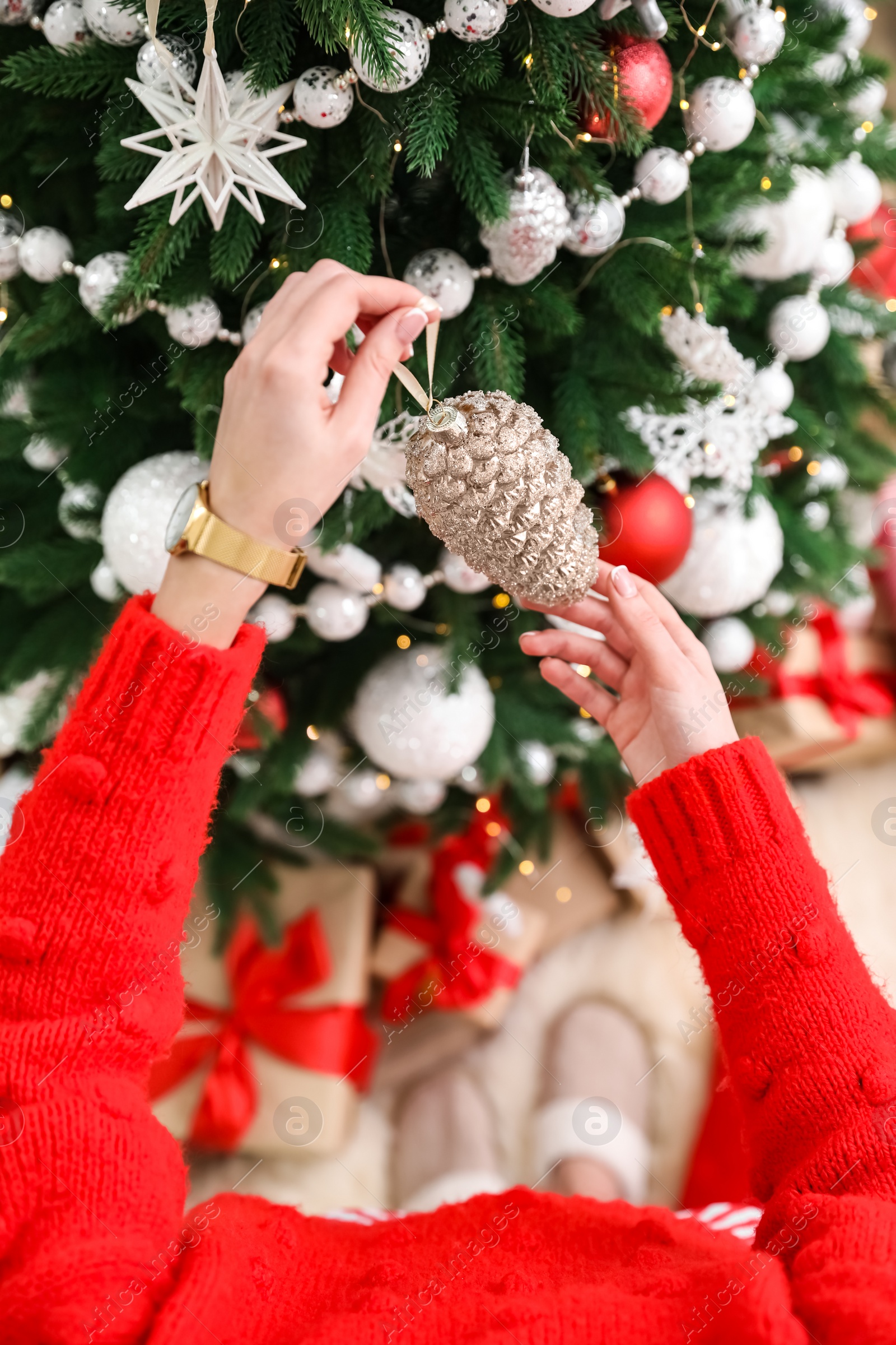 Photo of Woman decorating Christmas tree at home, top view