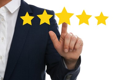 Image of Quality evaluation. Businessman touching virtual golden star on white background, closeup