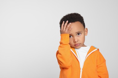 Emotional African-American boy on light grey background. Space for text