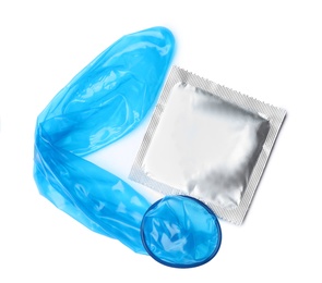 Unrolled blue condom and package on white background, top view. Safe sex