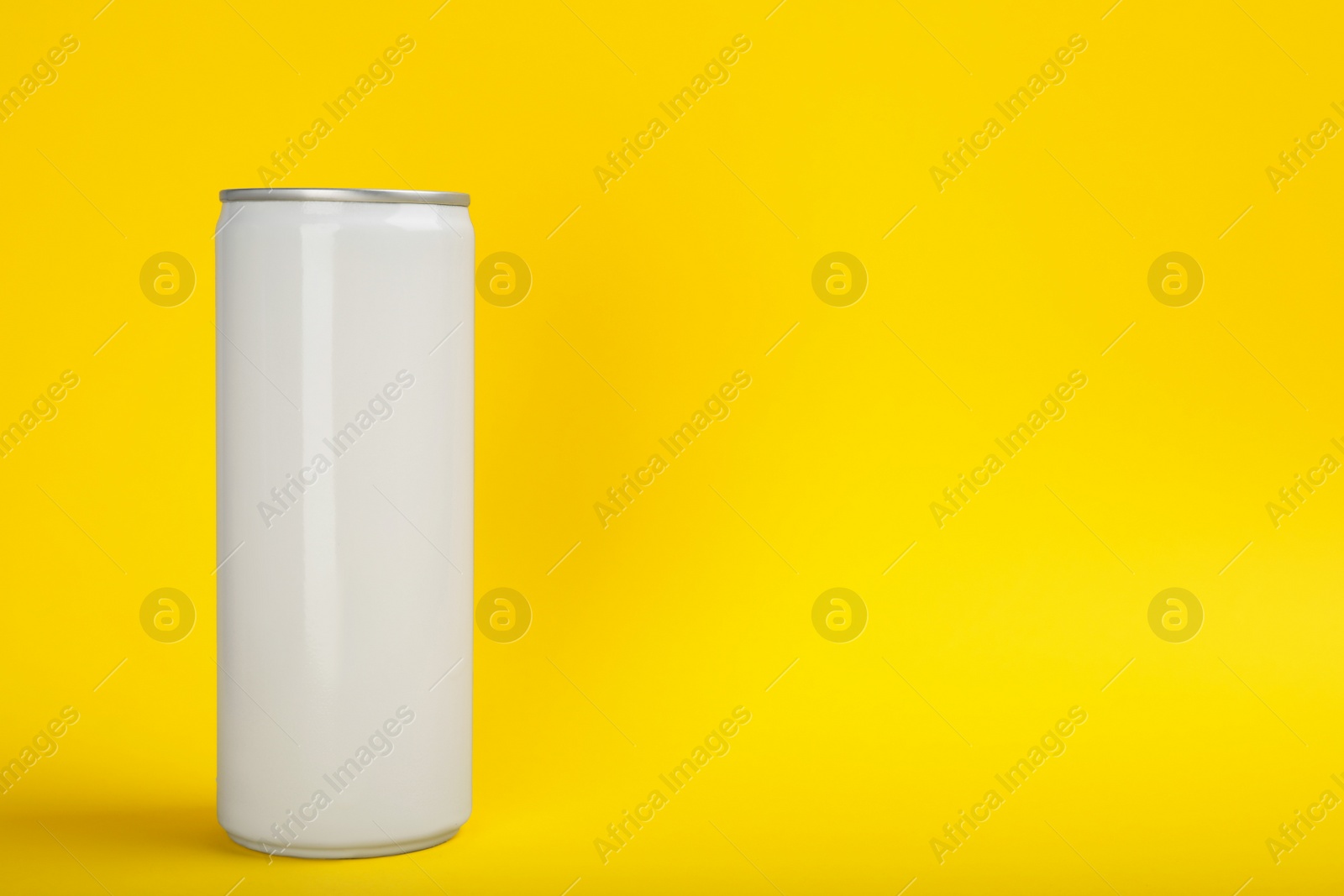 Photo of White can of energy drink on yellow background. Space for text