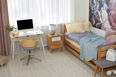 Stylish teenager's room interior with computer and comfortable bed