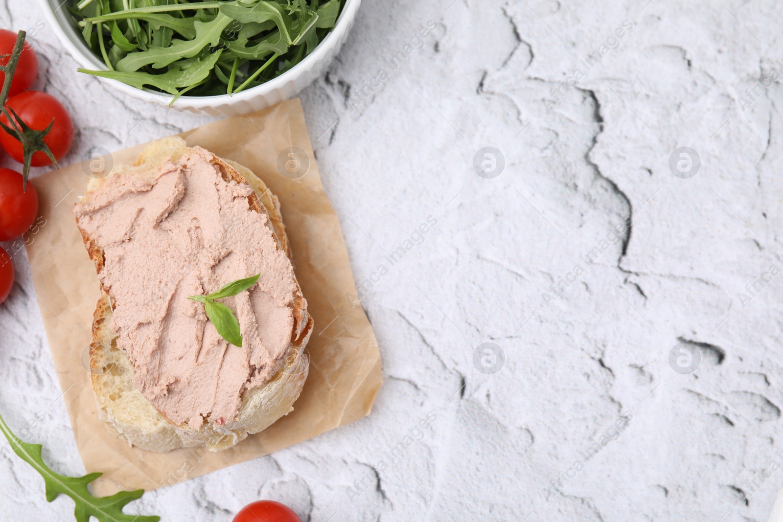 Photo of Delicious liverwurst sandwich with basil and ingredients on white textured table, flat lay. Space for text