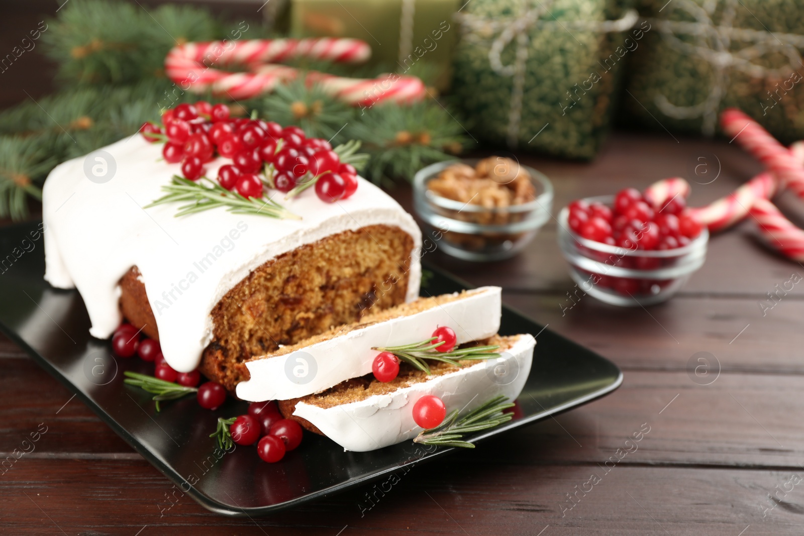 Photo of Traditional classic Christmas cake decorated with cranberries and rosemary on wooden table