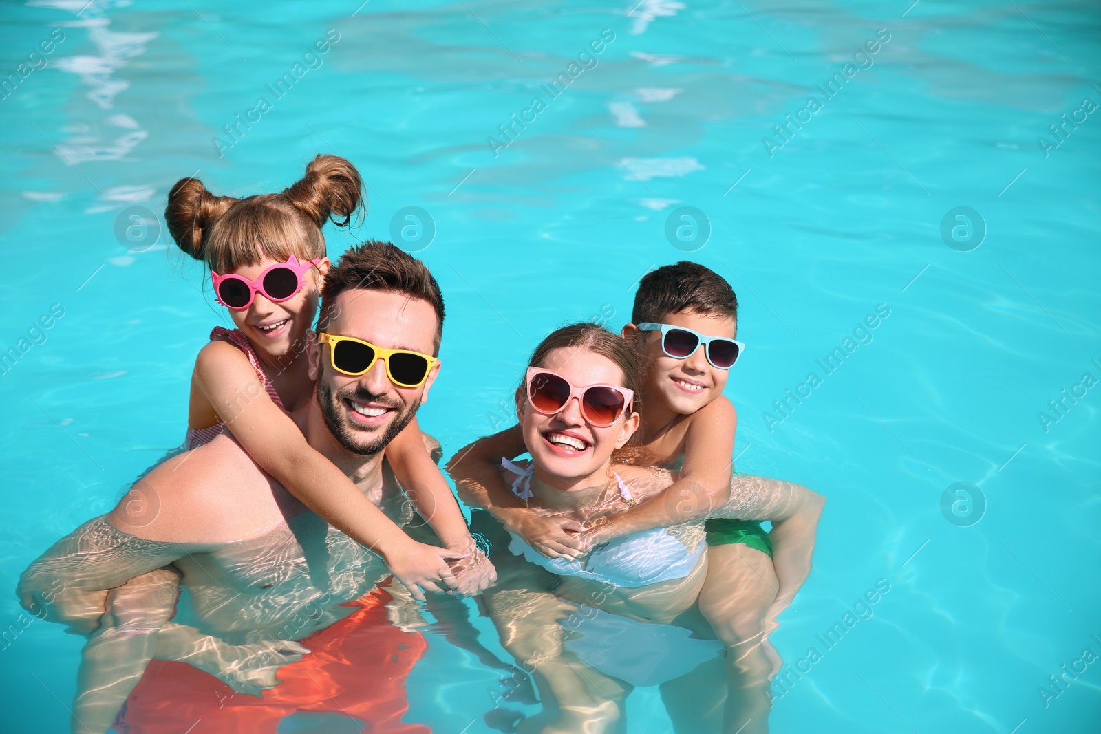 Photo of Happy family in swimming pool on sunny day