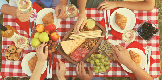 Young people having picnic at table in park, top view. Banner design