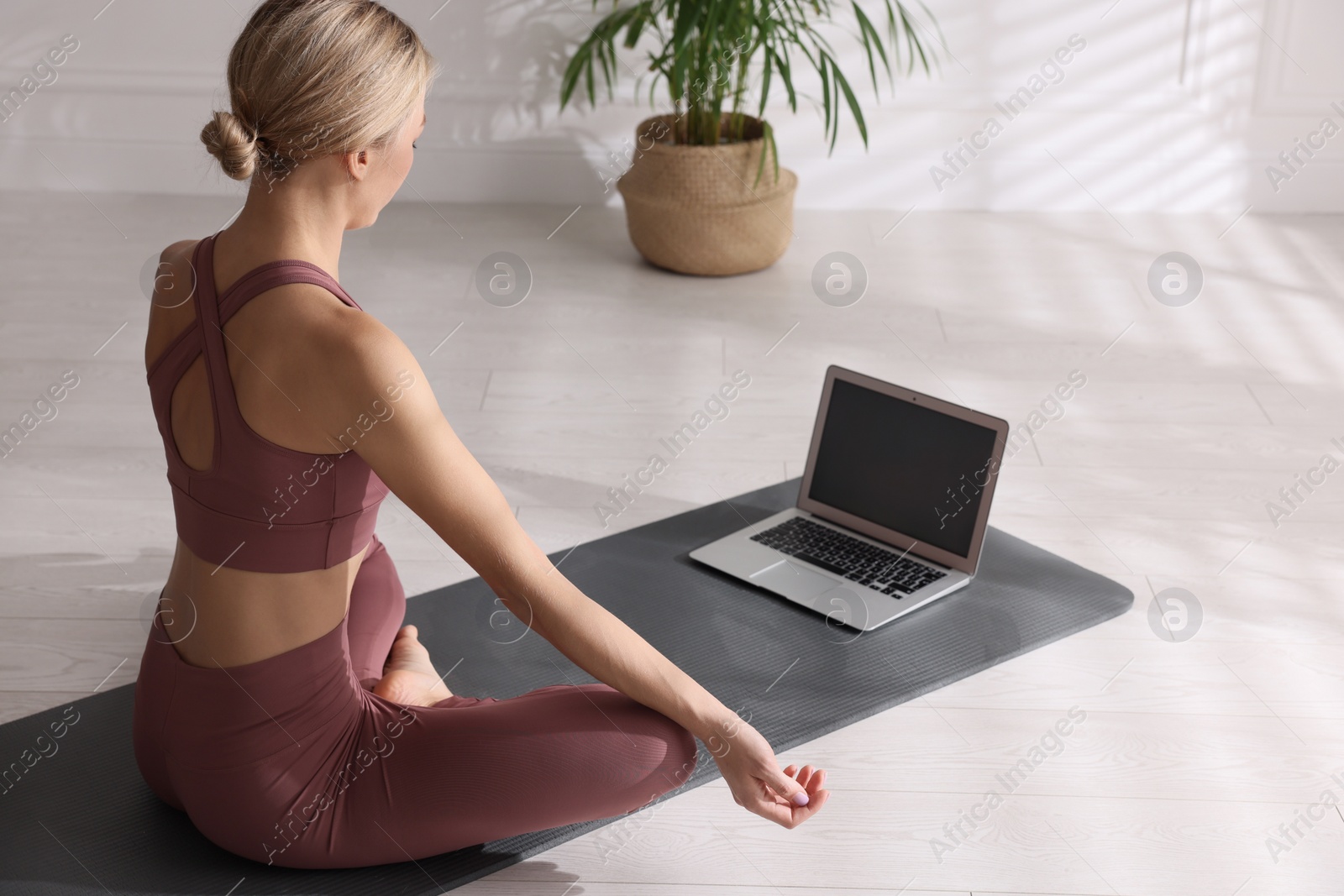 Photo of Woman watching online yoga class at home
