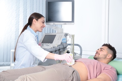 Photo of Doctor conducting ultrasound examination of patient's abdomen in clinic