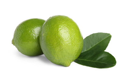 Photo of Fresh ripe limes with green leaves isolated on white