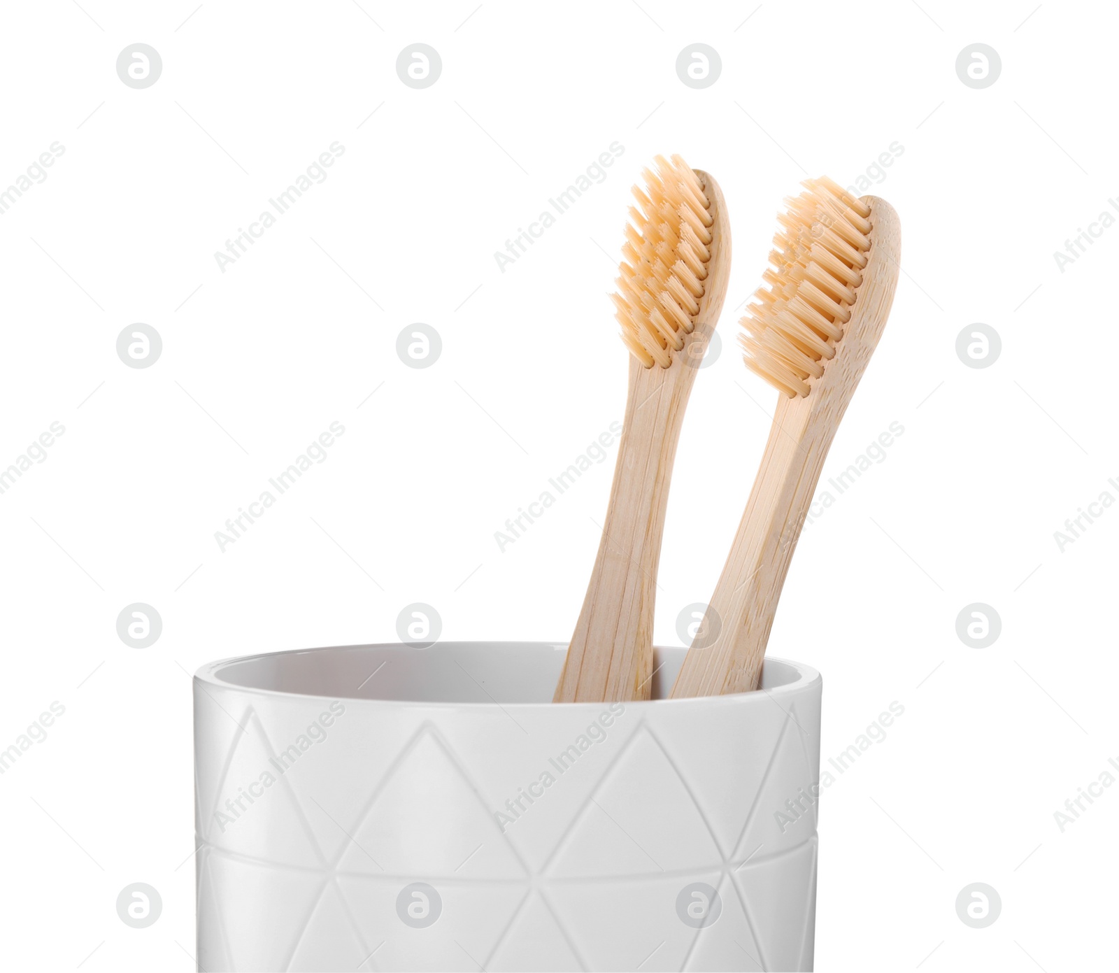 Photo of Bamboo toothbrushes in holder isolated on white