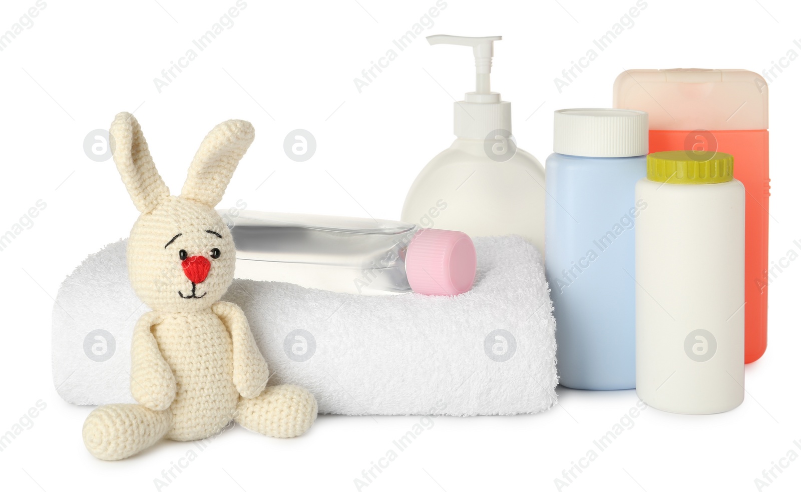 Photo of Bottles of baby cosmetic products, towel and toy bunny on white background