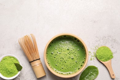 Bowl of fresh matcha tea, bamboo whisk and powder on light table, flat lay. Space for text