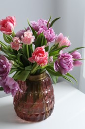 Beautiful bouquet of colorful tulip flowers on white table