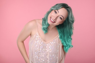 Trendy hairstyle. Young woman with colorful dyed hair on pink background