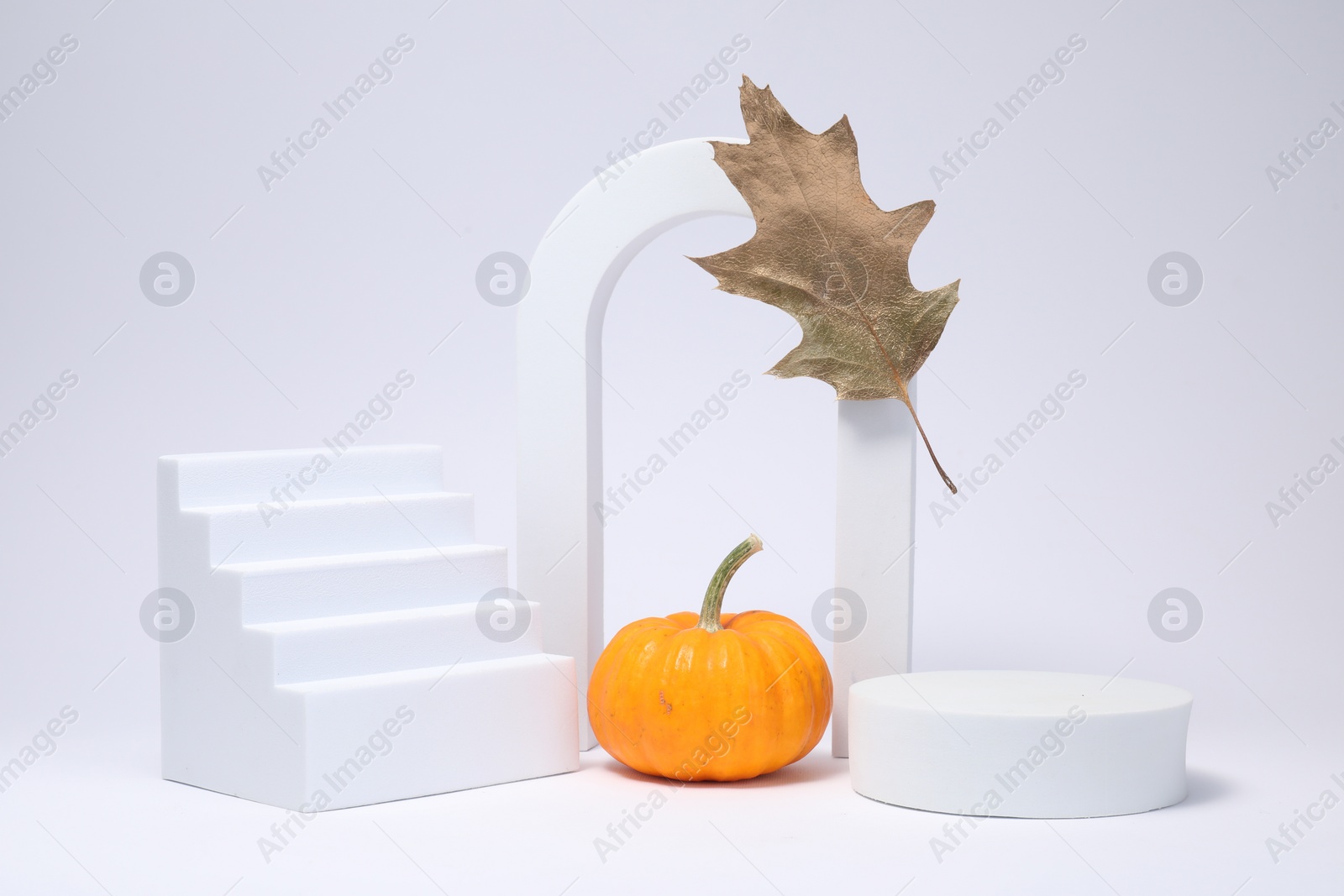 Photo of Autumn presentation for product. Geometric figures, pumpkin and golden leaf on white background