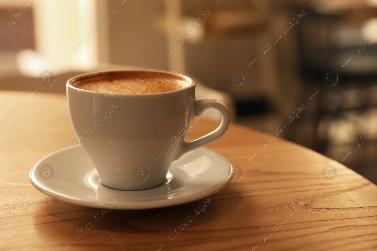 Photo of Cup of aromatic hot coffee on wooden table in cafe, closeup. Space for text