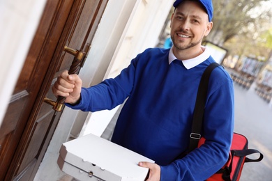 Male courier with order at entrance. Food delivery service