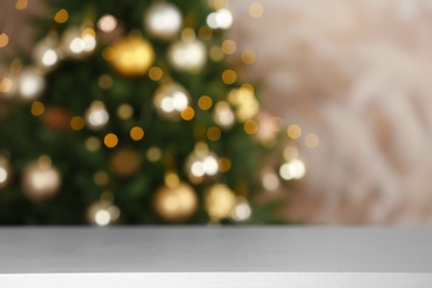 Photo of Empty table and blurred fir tree with Christmas lights on background, bokeh effect. Space for design