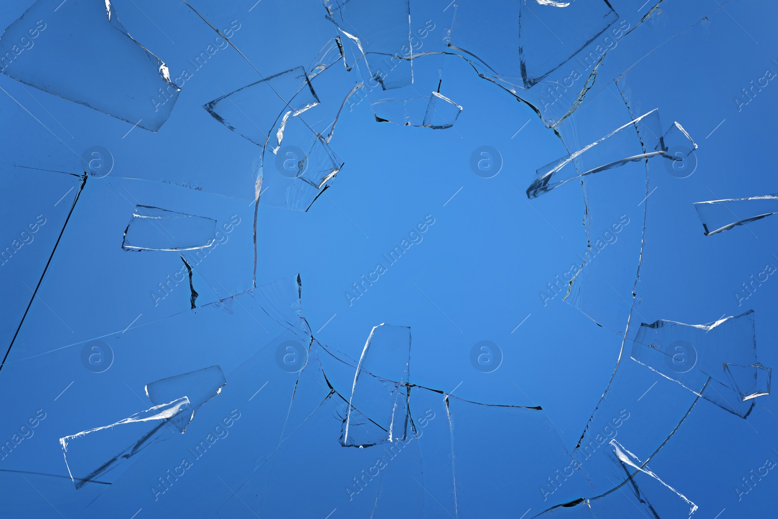 Image of Broken glass with cracks on blue background