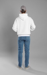 Photo of Young man in sweater on grey background. Mock up for design