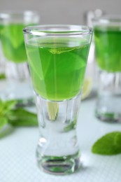 Photo of Delicious mint liqueur with lime on table, closeup