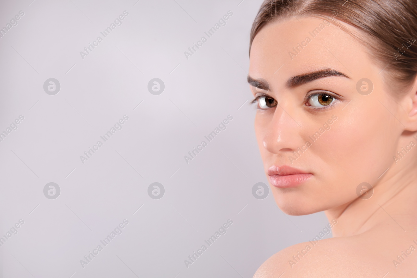 Photo of Beautiful woman with perfect eyebrows on light background