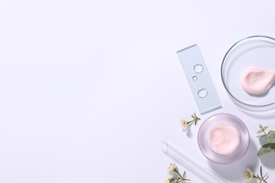 Organic cosmetic product, natural ingredients and laboratory glassware on white background, top view. Space for text