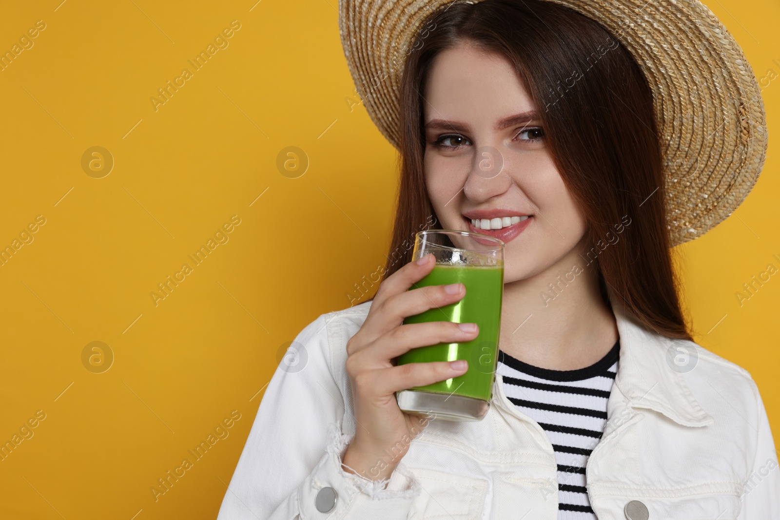 Photo of Beautiful young woman with glass of juice on yellow background. Space for text