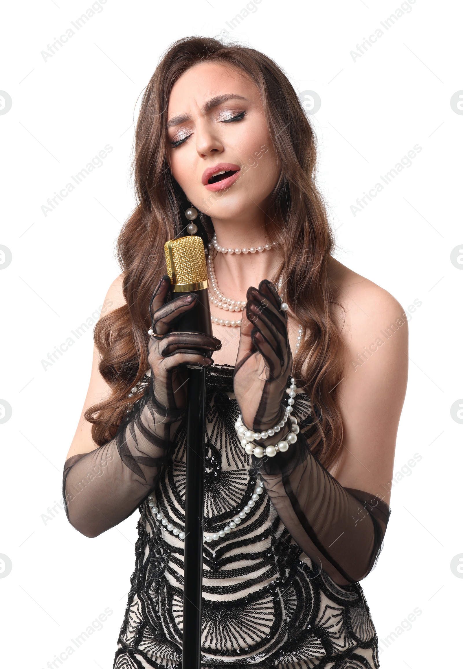 Photo of Beautiful young woman in stylish dress with microphone singing on white background