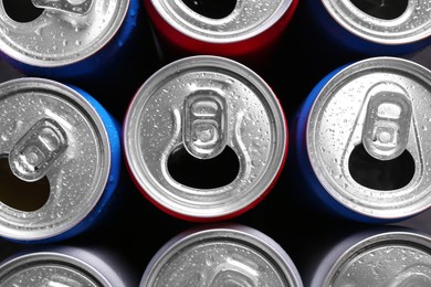Photo of Energy drinks in wet cans as background, top view. Functional beverage