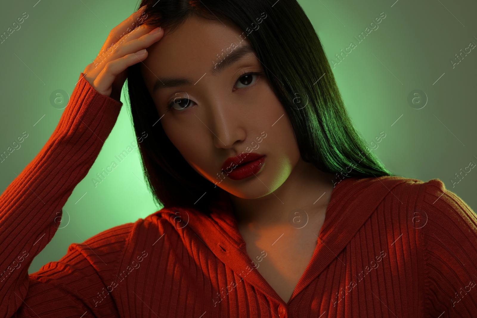 Photo of Portrait of beautiful young Asian woman on green background