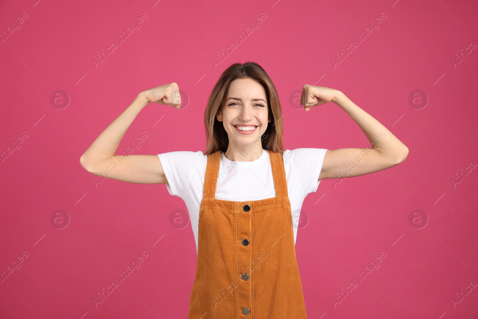 Photo of Strong woman as symbol of girl power on pink background. 8 March concept