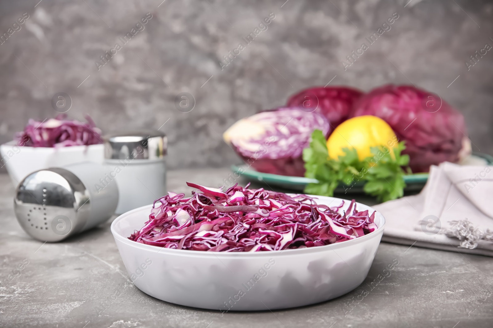 Photo of Bowl with chopped purple cabbage on table