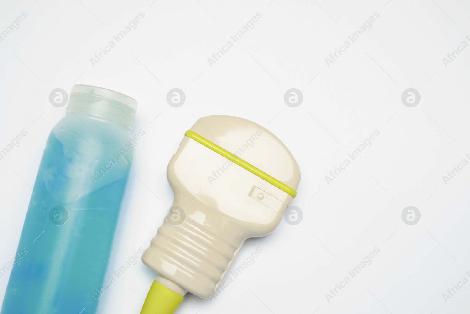 Photo of Ultrasonic transducer and ultrasound transmission gel on light background, flat lay. Space for text