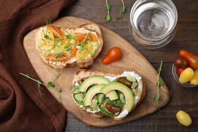 Photo of Tasty vegan sandwiches with vegetables on wooden table, flat lay