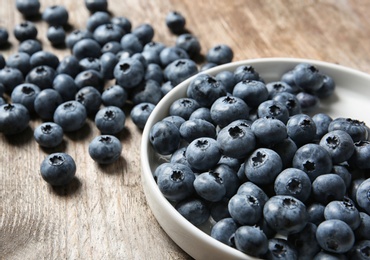 Photo of Juicy and fresh blueberries on wooden table, closeup
