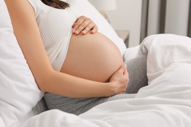 Photo of Pregnant woman in bed at home, closeup