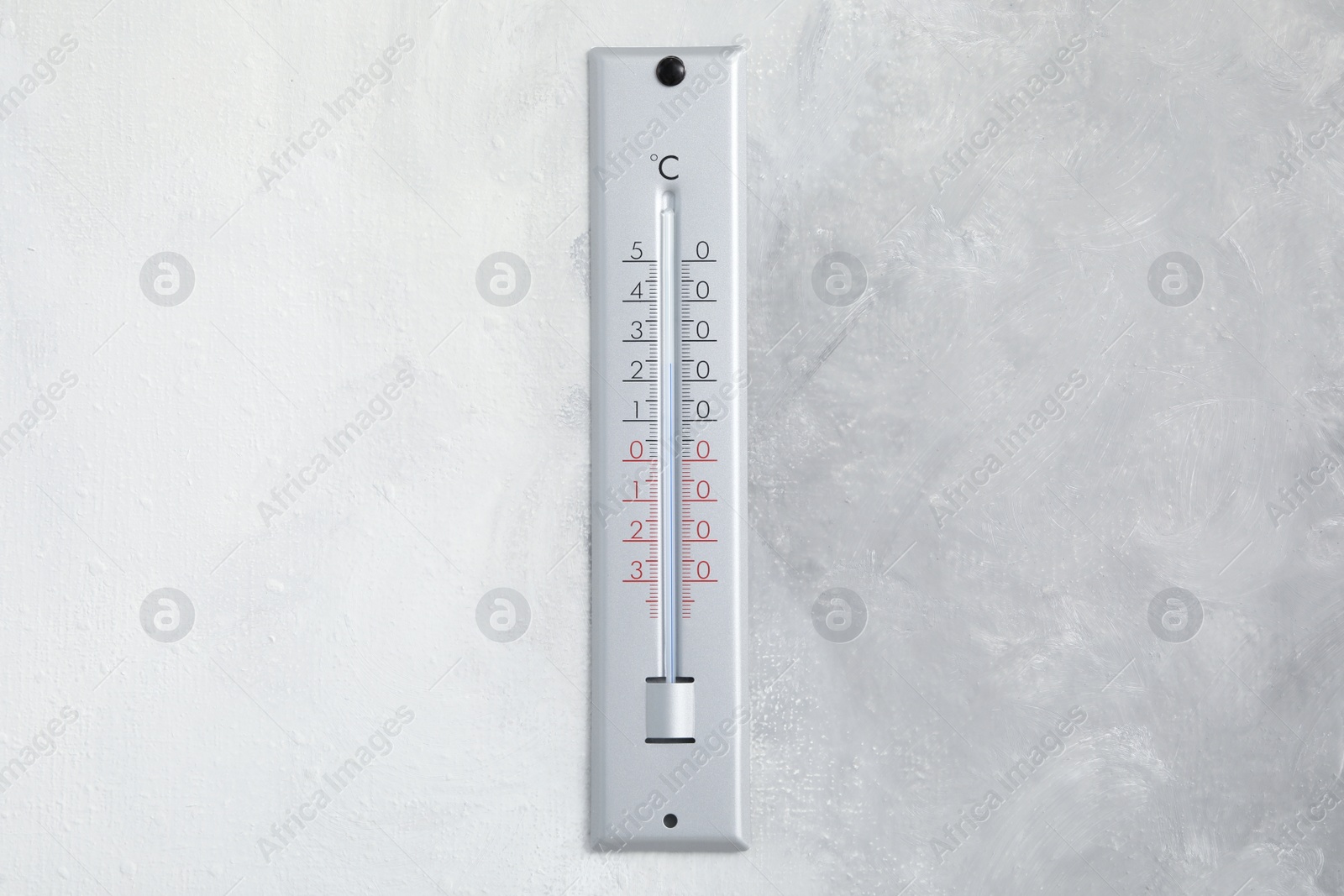 Photo of Weather thermometer hanging on light grey wall