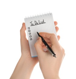 Woman filling To Do list in notepad on white background, closeup