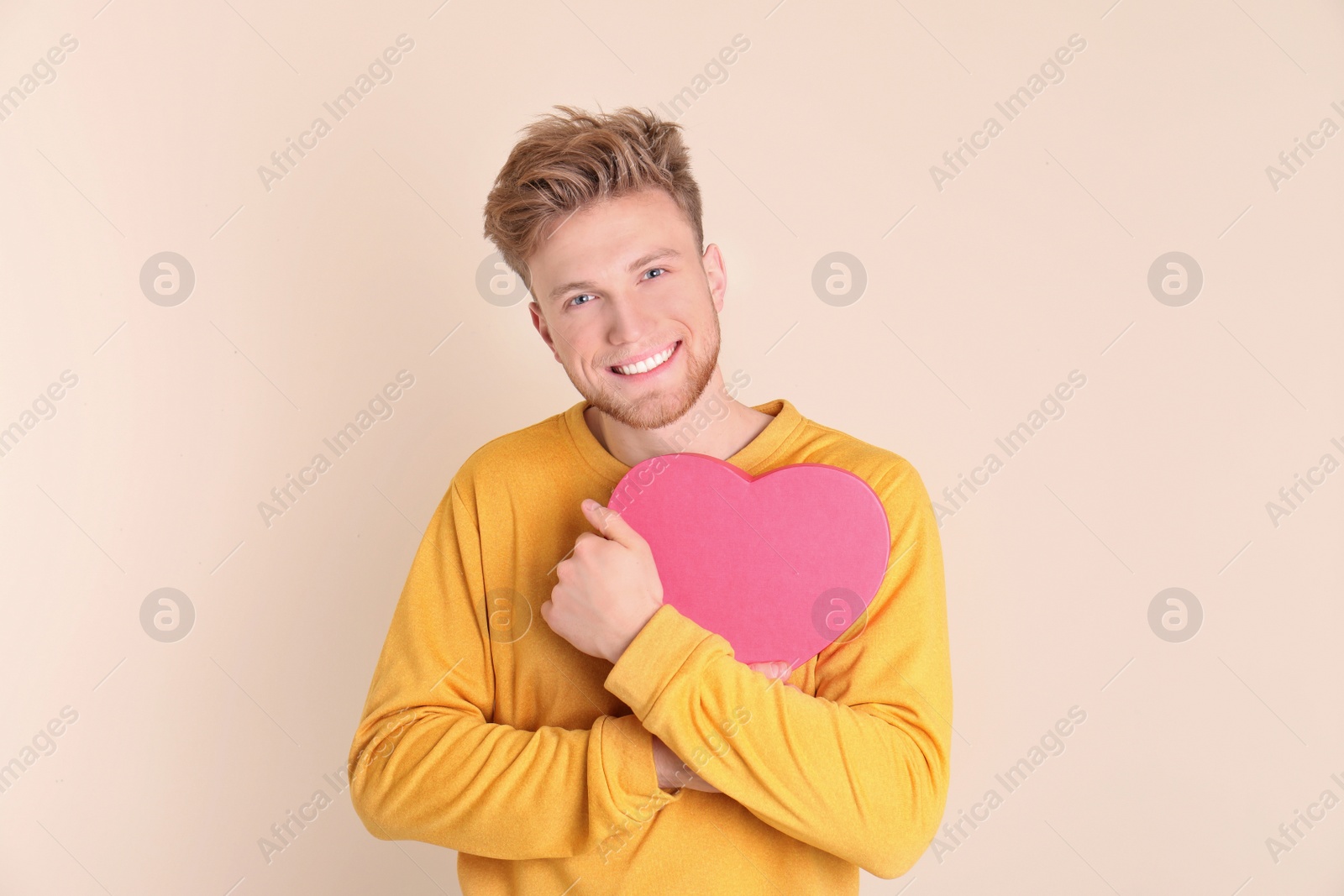 Photo of Portrait of young man with decorative heart on color background