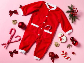 Flat lay composition with cute Christmas baby clothes on pink background