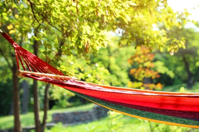 Bright comfortable hammock hanging in green garden
